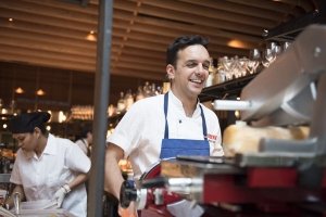 Chef Marc Vidal smiles while working in the kitchen of Boqueria Spanish restaurant and tapas bar in NYC and DC.