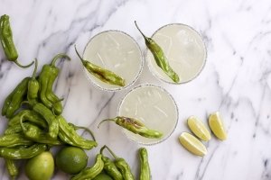A Shishito Margarita happy hour drink, served with fresh limes at Boqueria Spanish tapas bar and Spainish restaurant with happy hour.