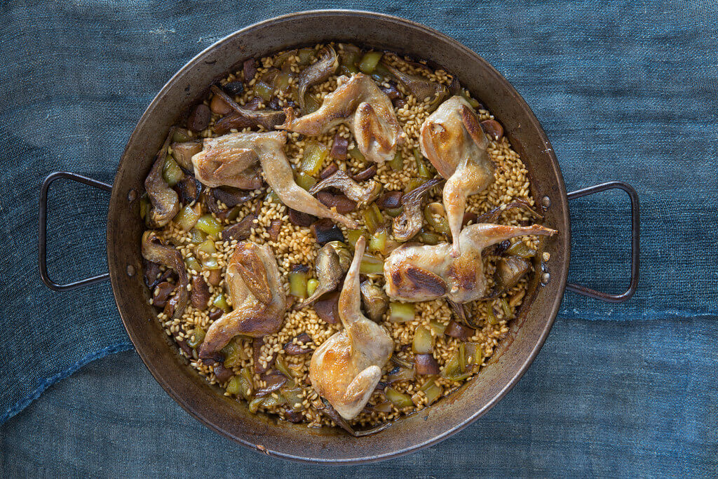 Spanish quail and porcini mushroom rice with artichokes served in large at Boqueria Spanish restaurant in NYC and DC.