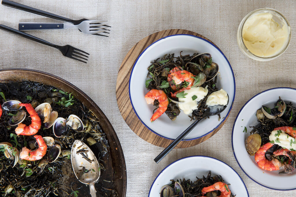 Fideua Negra served on a white plate at Boqueria Spanish tapas restaurant located in NYC and Washington DC.