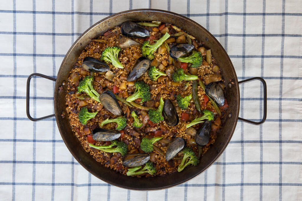 Chicken and seafood paella served in a large skillet from Boqueria Spanish tapas restaurant located in NYC and Washington DC.