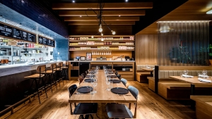 The main dining area available for private events in D.C. at Boqueria Penn Quarter. A large dining table next to the open kitchen and spanish pantry.